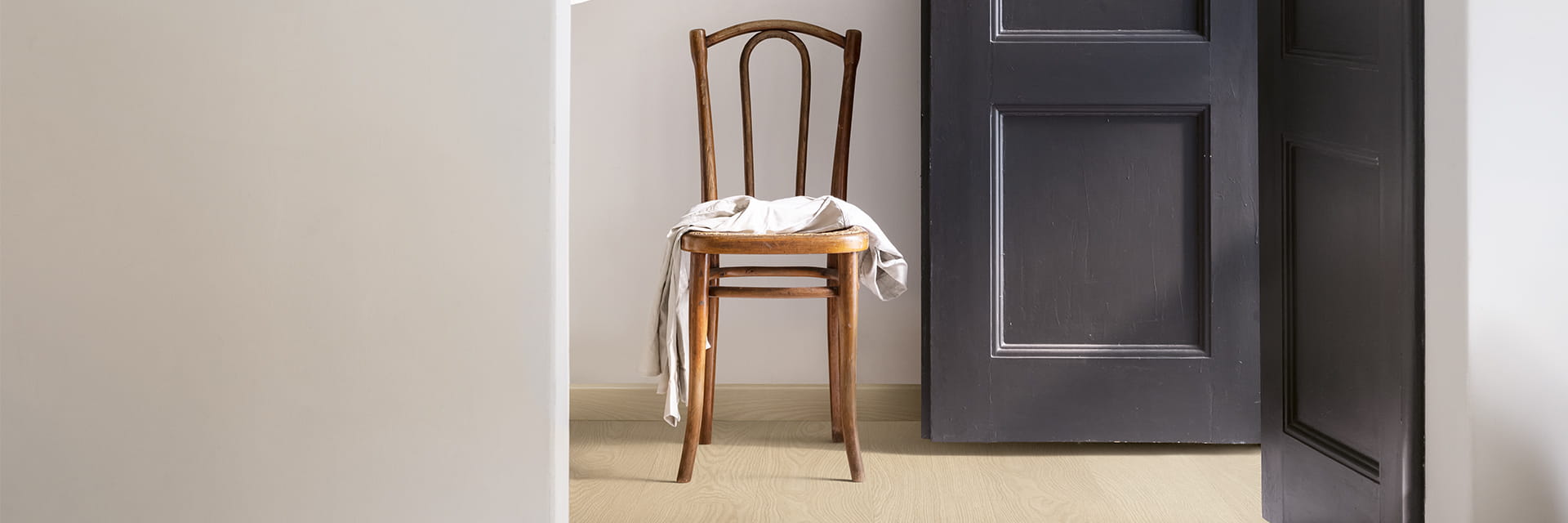 eteisessä oleva beige vinyylilattia ja tuoli, jossa on takki